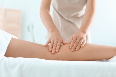 Photo of Woman receiving leg massage in wellness center, closeup