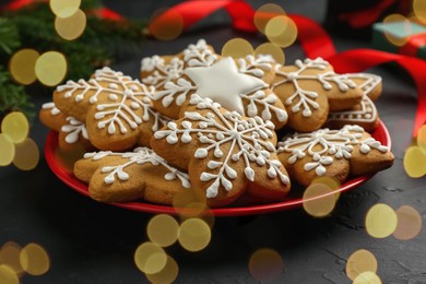 Tasty Christmas cookies with icing on black table, closeup