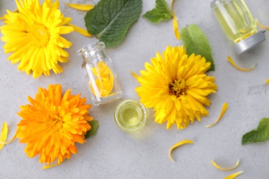 Flat lay composition with essential oils and ingredients on grey background