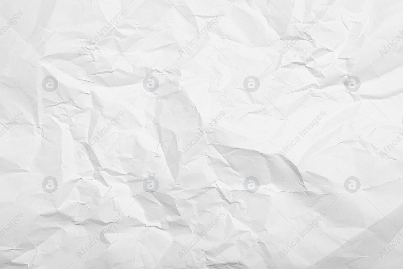 Photo of Sheet of white crumpled paper as background, closeup