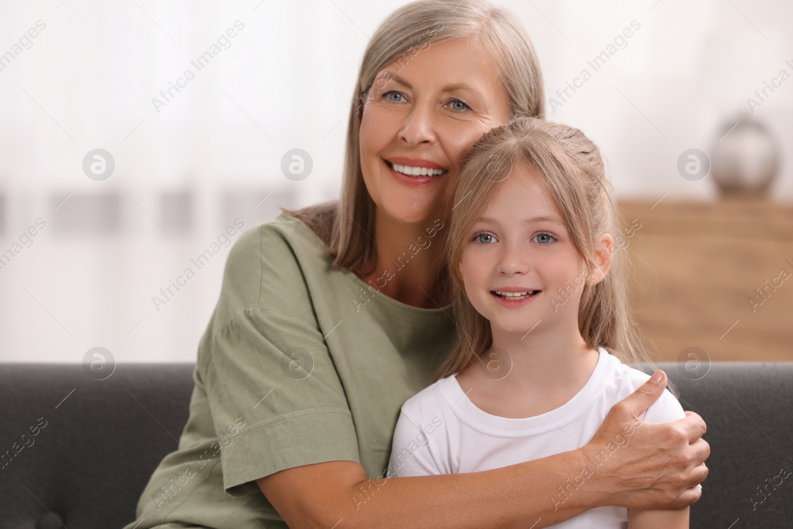 Photo of Happy grandmother with her granddaughter at home