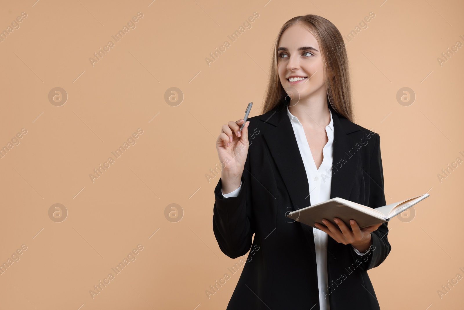 Photo of Happy young secretary with notebook and pen on beige background, space for text