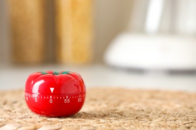 Photo of Kitchen timer in shape of tomato on wicker mat indoors. Space for text