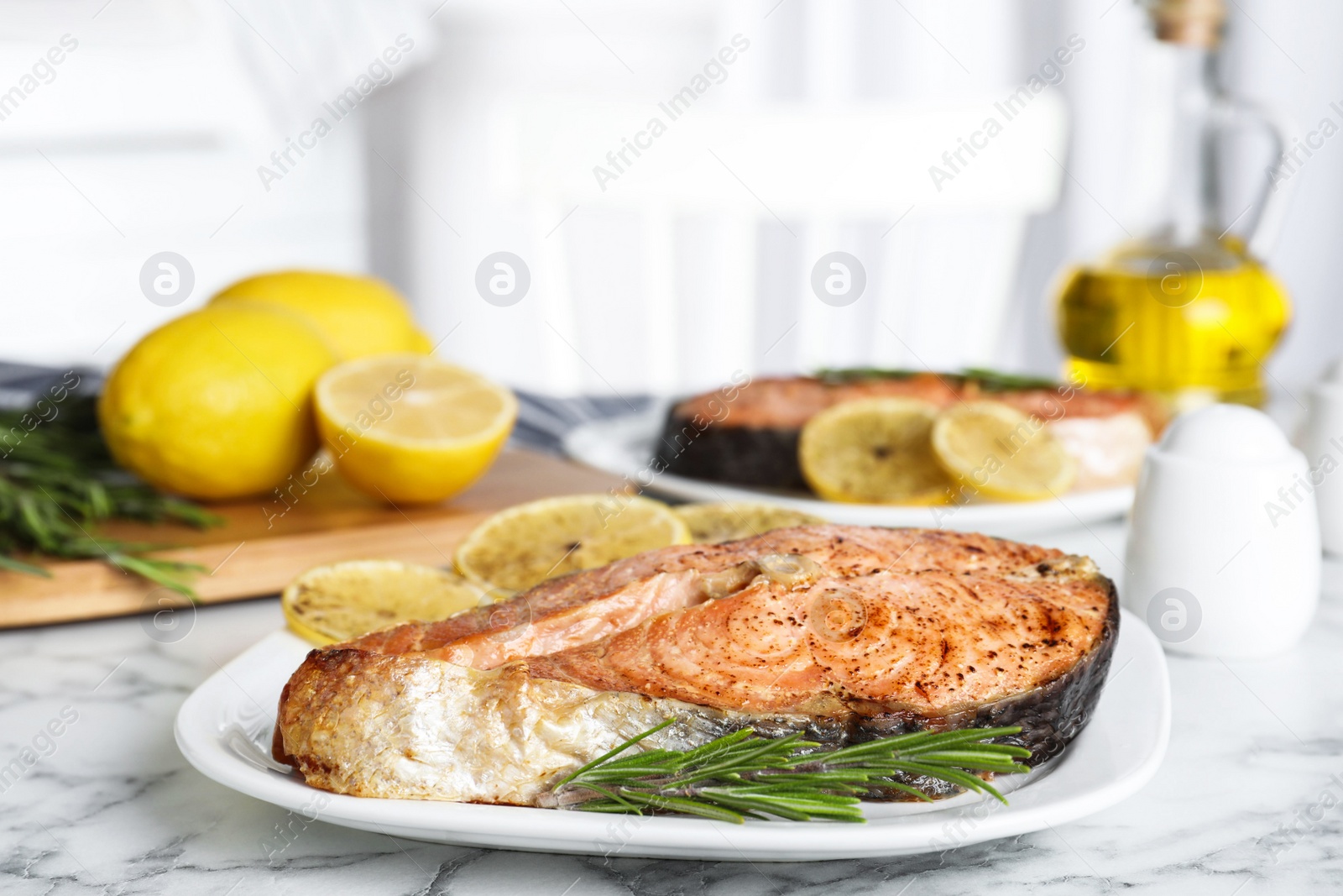 Photo of Tasty cooked red fish on white marble table