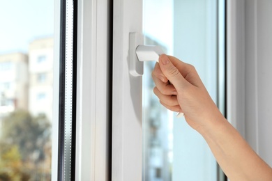 Photo of Woman opening new modern window, closeup view