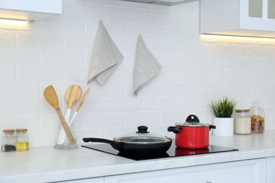 Photo of Red pot and frying pan on stove in kitchen