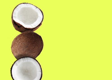 Image of Stack of fresh coconuts on light yellow background. Space for text