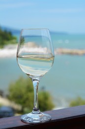 Photo of Glass with wine on railing near sea