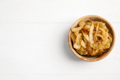 Photo of Tasty fried onion on white wooden table, top view. Space for text