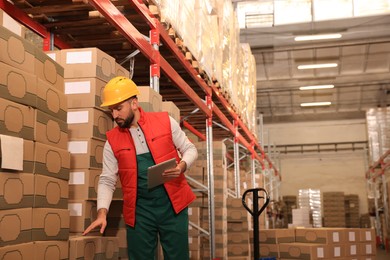 Man with tablet working at warehouse. Logistics center