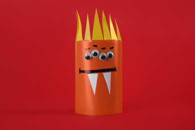 Funny orange monster on red background. Halloween decoration