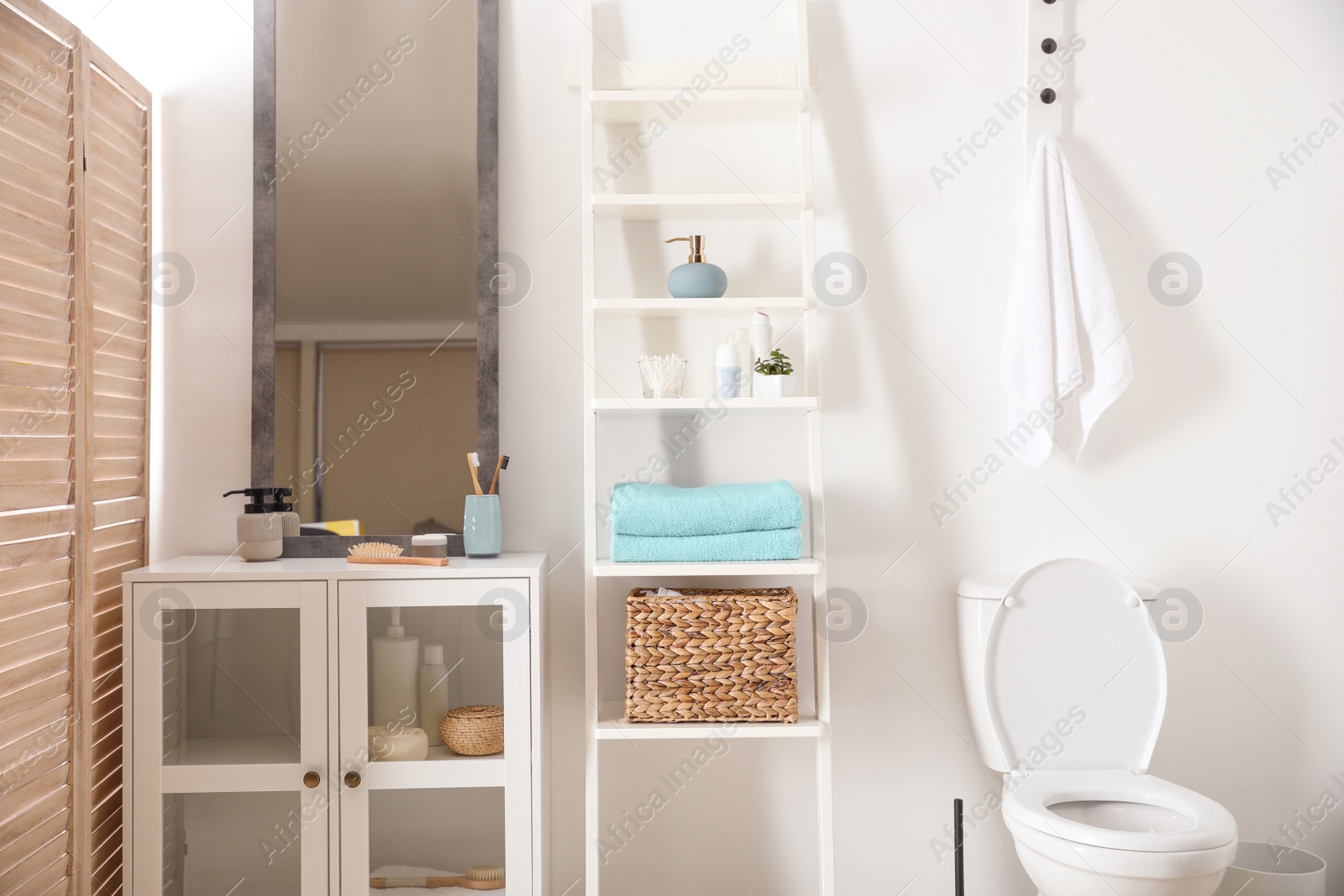 Photo of Large mirror and decorative ladder in modern bathroom