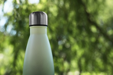 Photo of Closeup view of thermo bottle in park, space for text