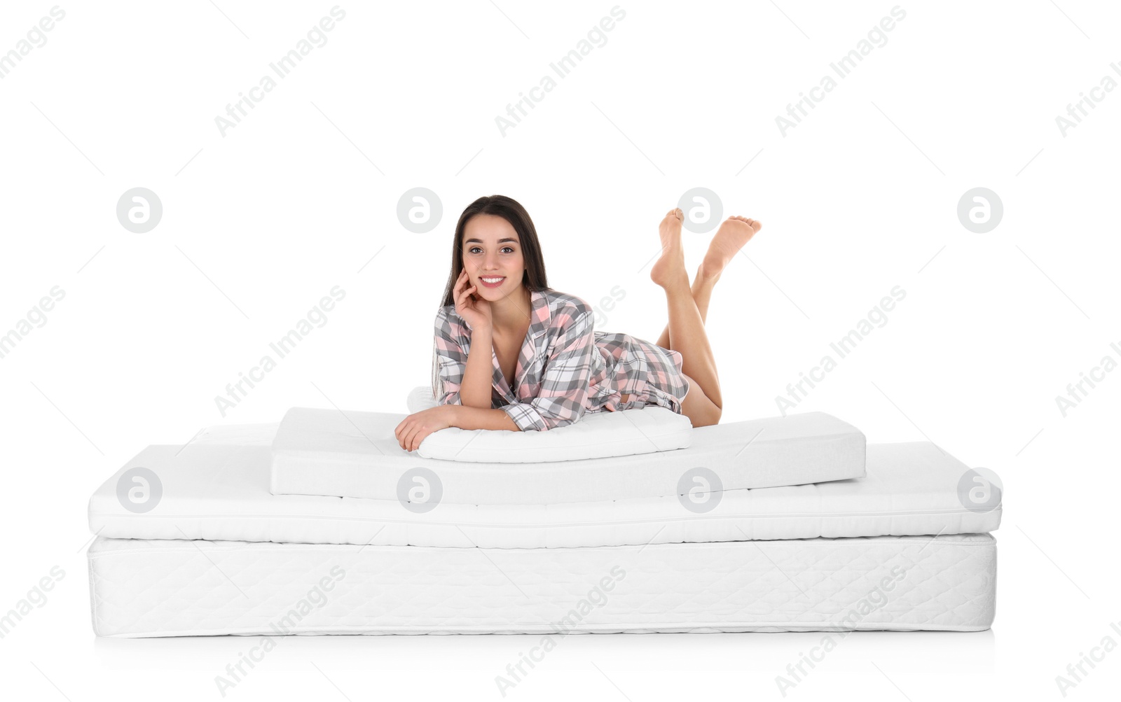 Photo of Young woman lying on mattress pile against white background