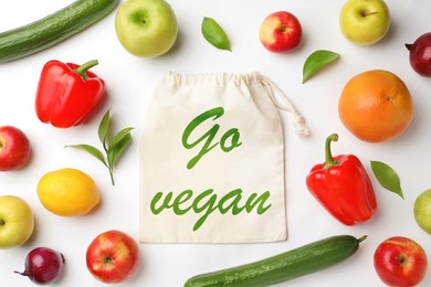 Image of Cotton eco bag with phrase Go Vegan, fruits and vegetables on white background, flat lay