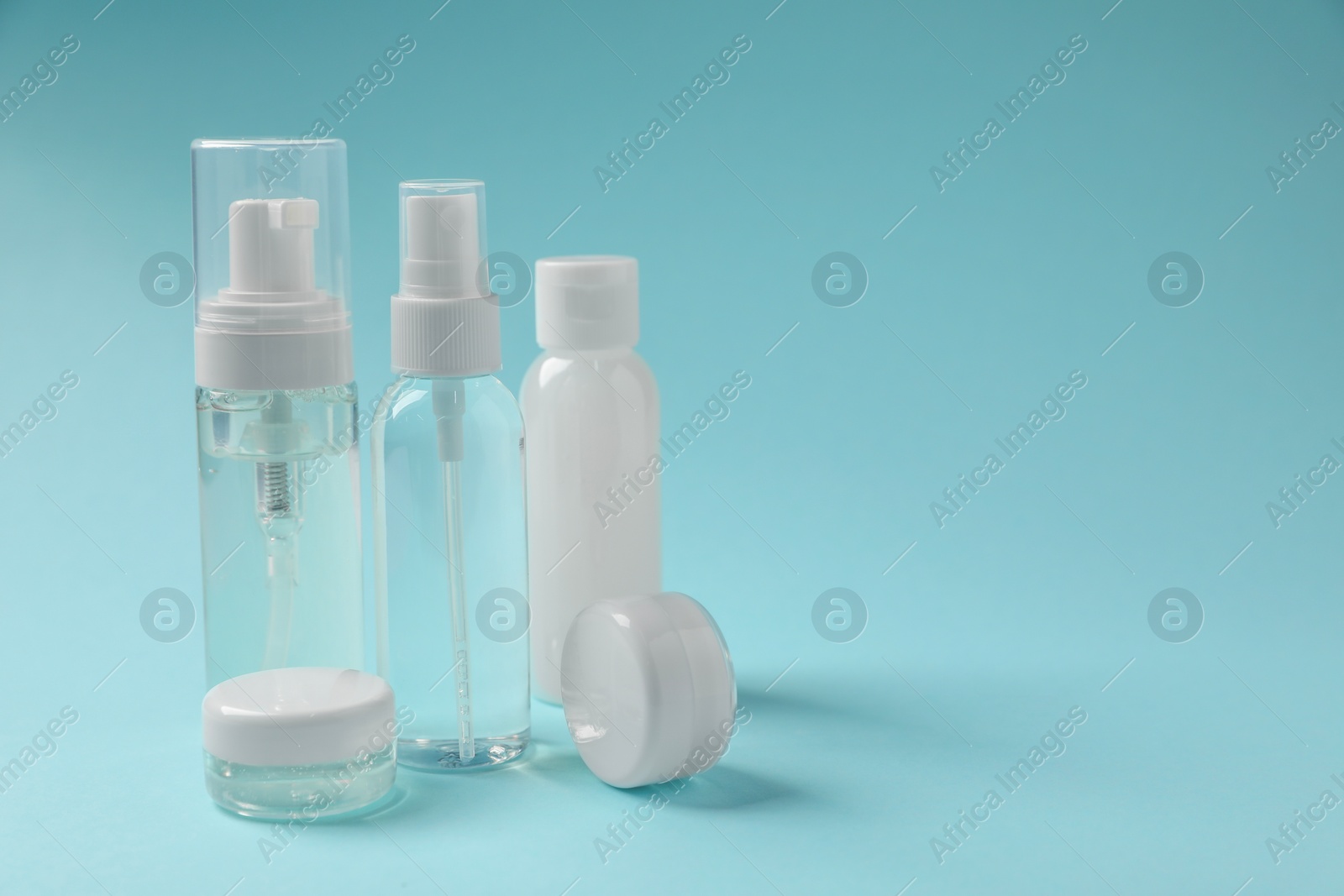 Photo of Cosmetic travel kit on light blue background, space for text. Bath accessories