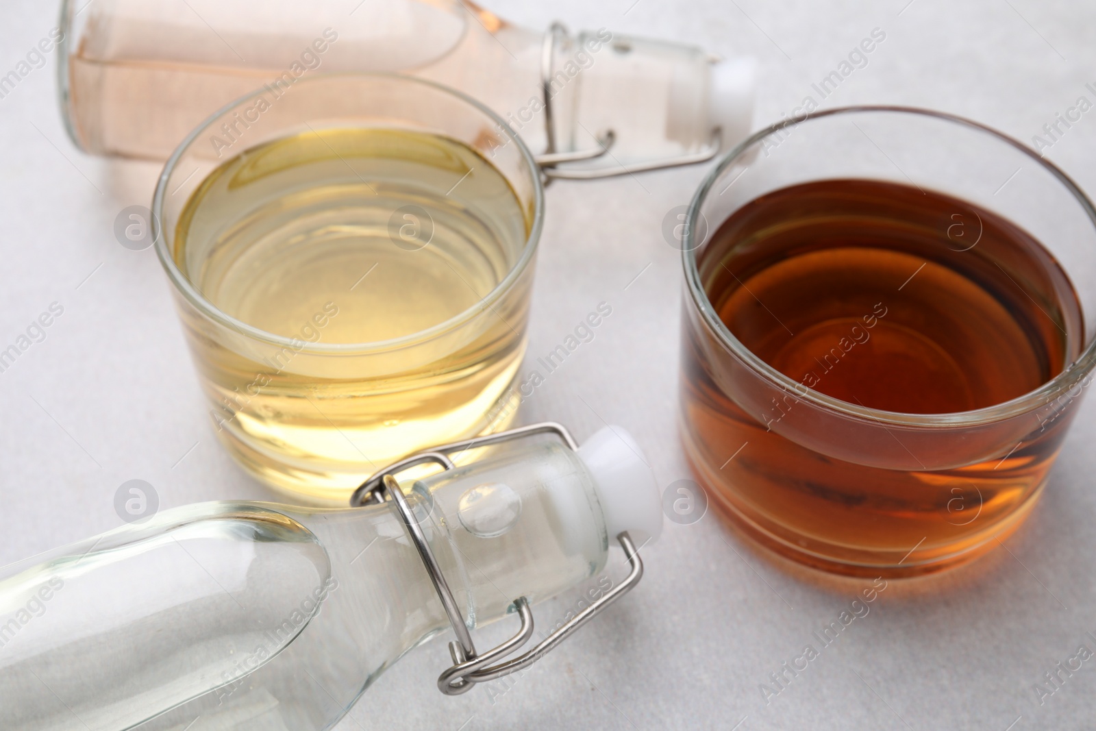 Photo of Different types of vinegar on light table, closeup