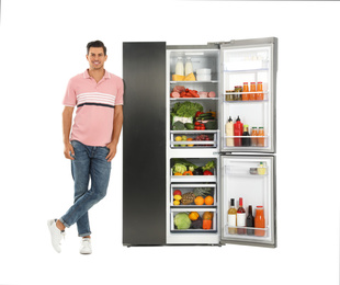 Photo of Man near open refrigerator on white background