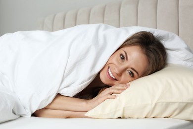 Portrait of happy beautiful woman in bed at home