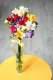 Beautiful freesia bouquet in vase on table