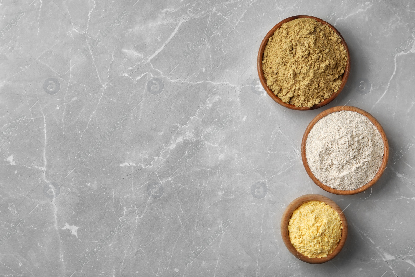 Photo of Bowls with different types of flour on light background