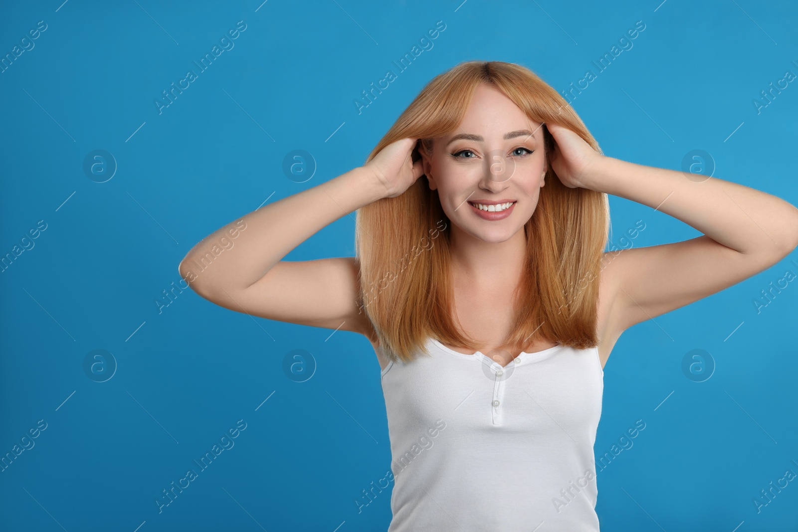 Photo of Beautiful young woman with blonde hair on blue background