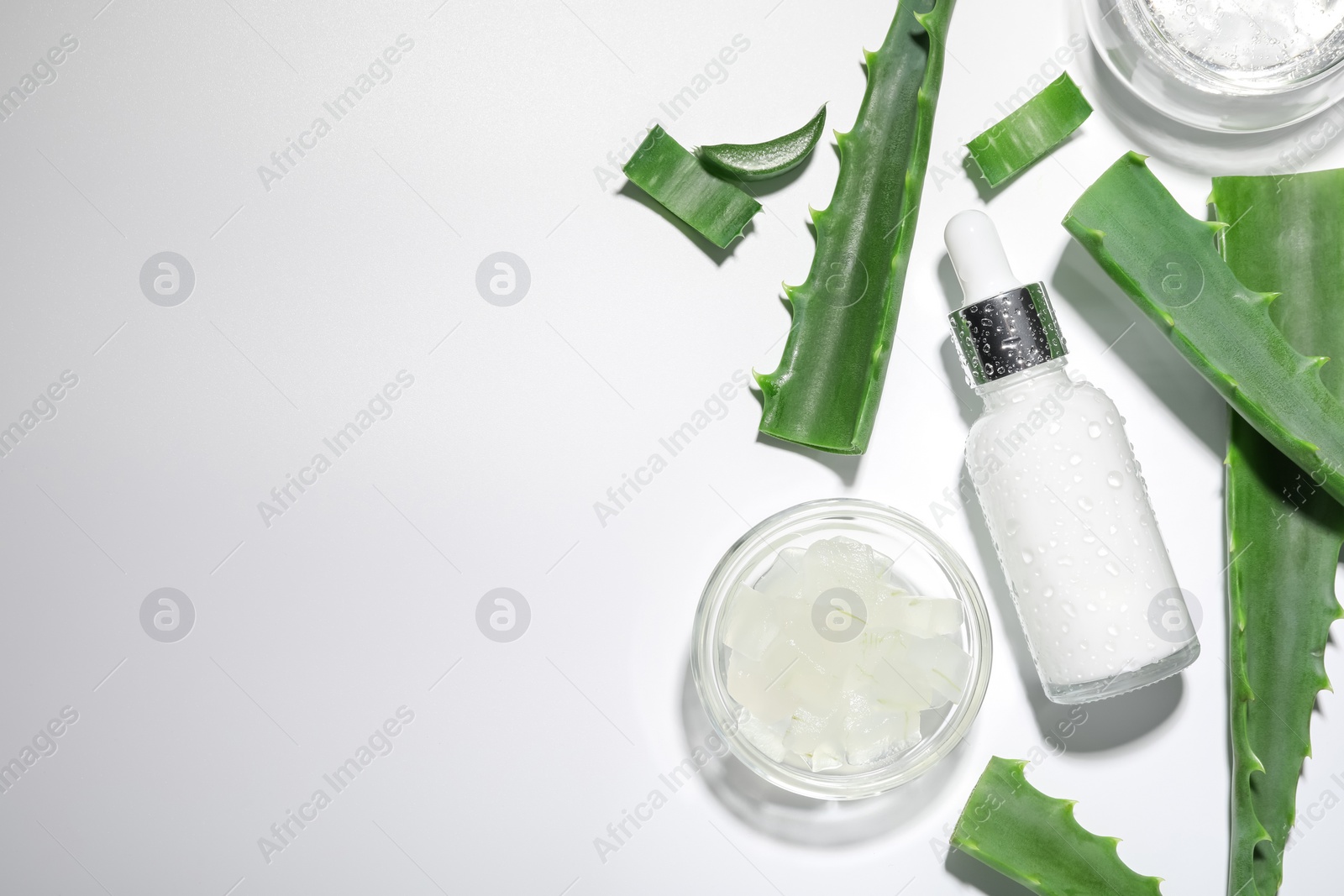 Photo of Flat lay composition with cosmetic products and cut aloe vera on white background. Space for text