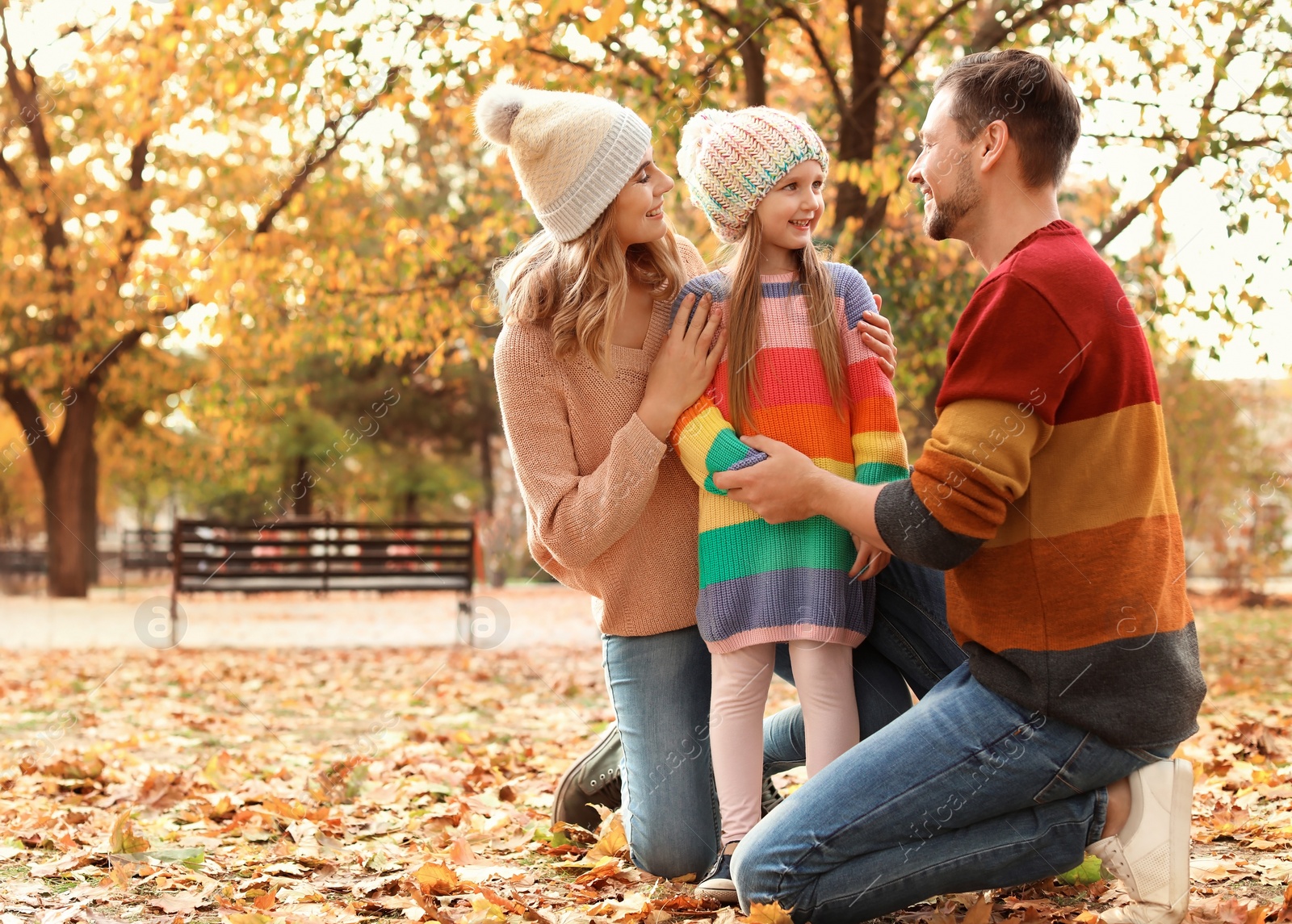 Photo of Happy family with child spending time together in park. Autumn walk