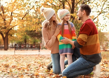 Photo of Happy family with child spending time together in park. Autumn walk