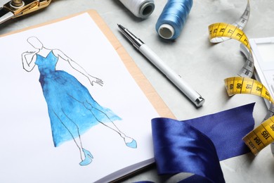 Photo of Drawing of dress on table, closeup. Designer's workplace