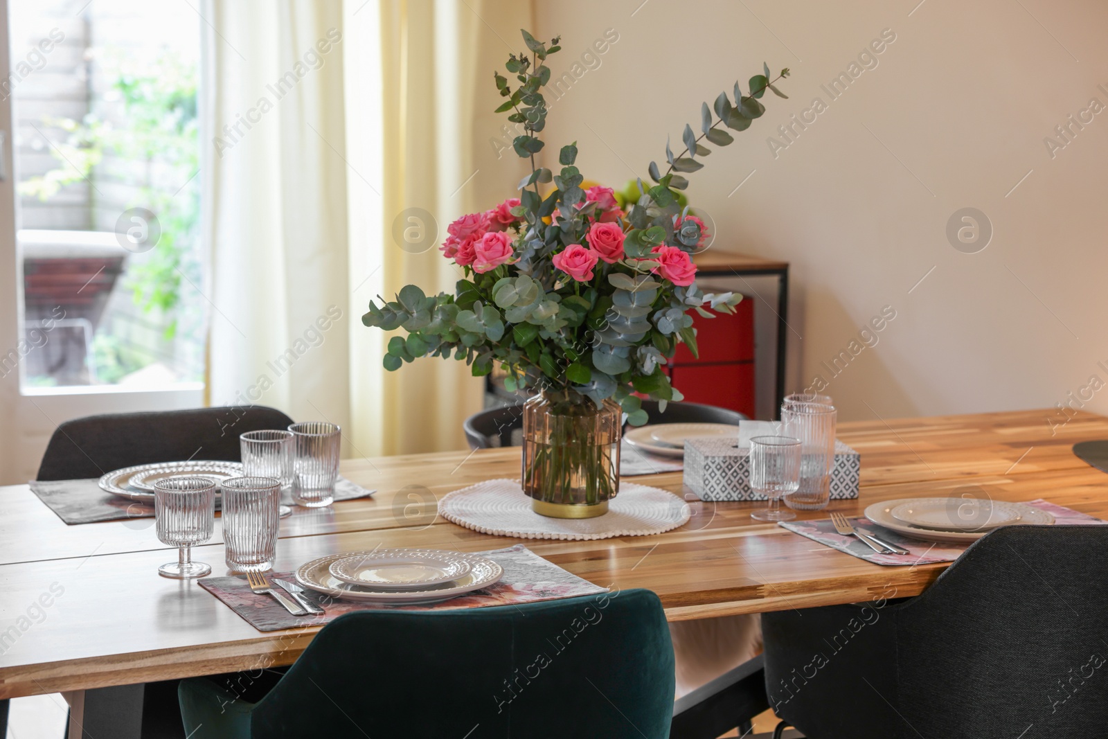 Photo of Beautiful table setting with bouquet indoors. Roses and eucalyptus branches in vase