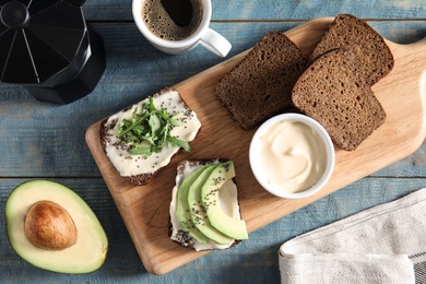 Slices of bread with different toppings on blue wooden table, flat lay