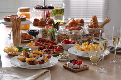 Photo of Variety of snacks on wooden table in buffet style indoors