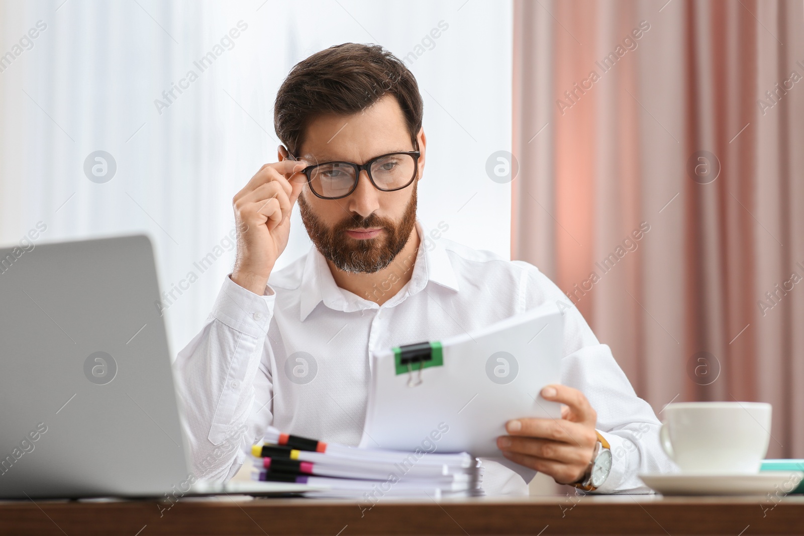 Photo of Businessman working with documents at wooden table in office