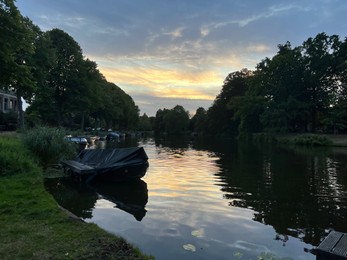 Picturesque view of river with moored boats in evening