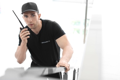 Photo of Male security guard with portable radio transmitter indoors