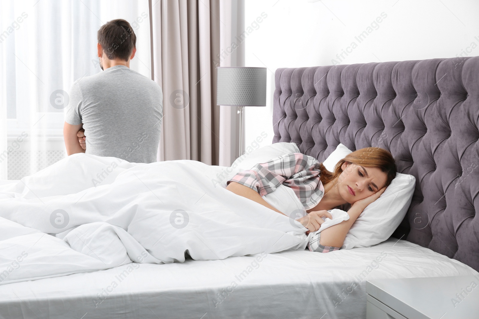 Photo of Couple with relationship problems ignoring each other in bedroom