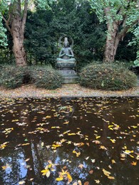 Photo of View of Buddha statue near lake in autumn park