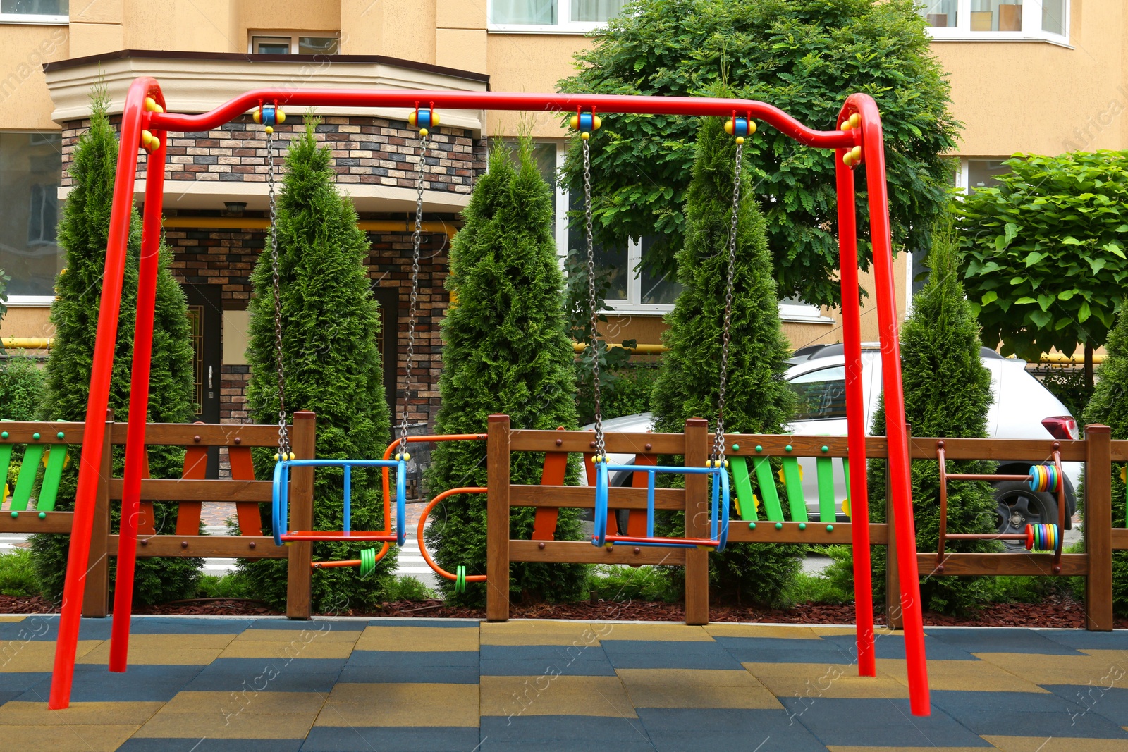 Photo of Empty outdoor children's playground with swings in residential area