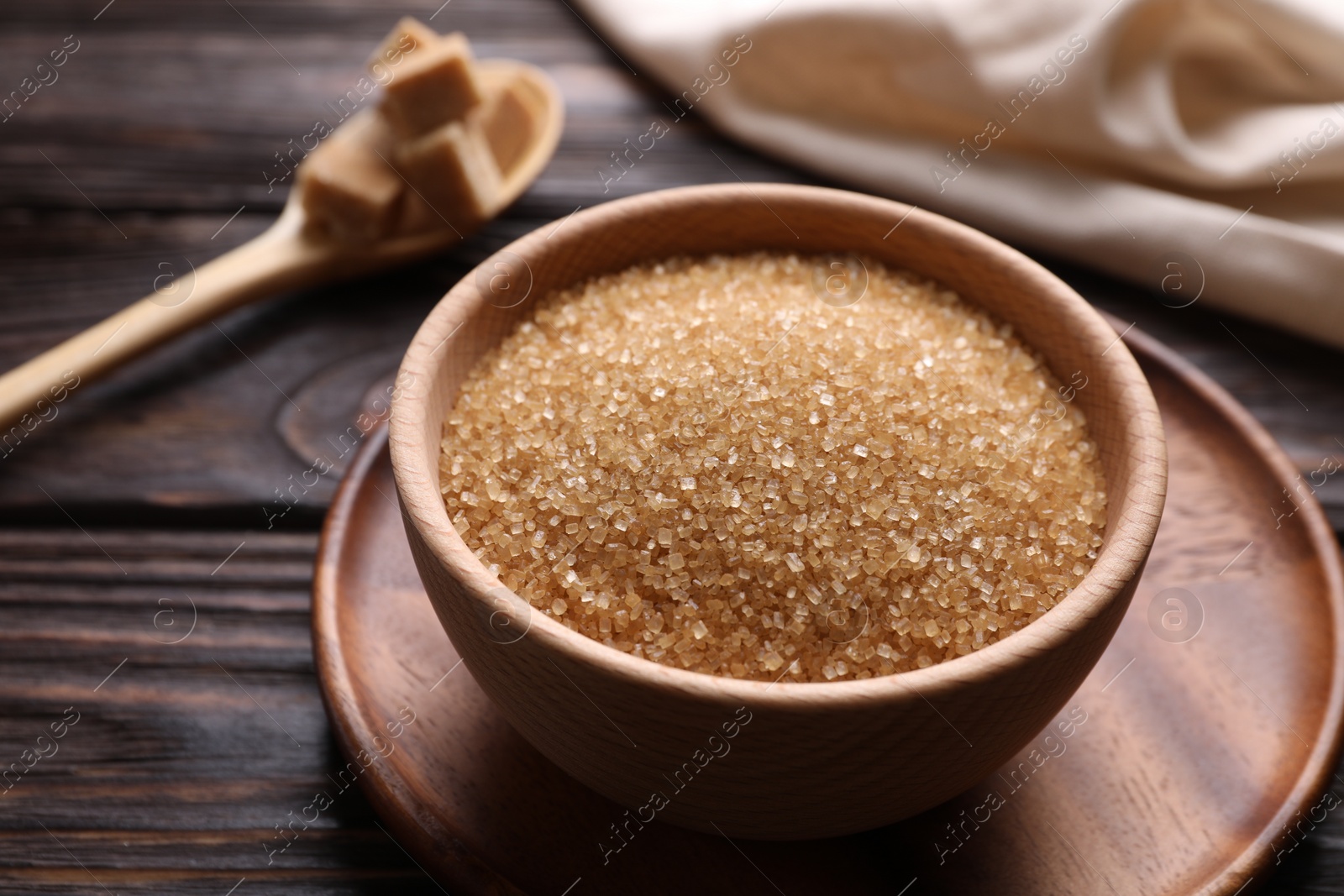 Photo of Brown sugar in bowl on wooden table, closeup