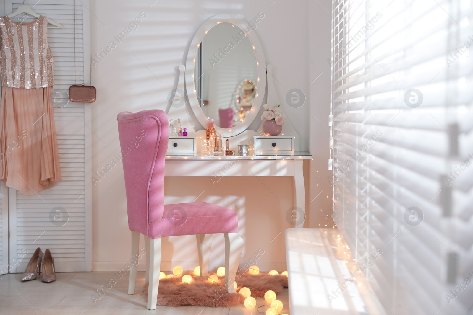 Photo of Elegant dressing table with lights and pink chair in stylish room interior