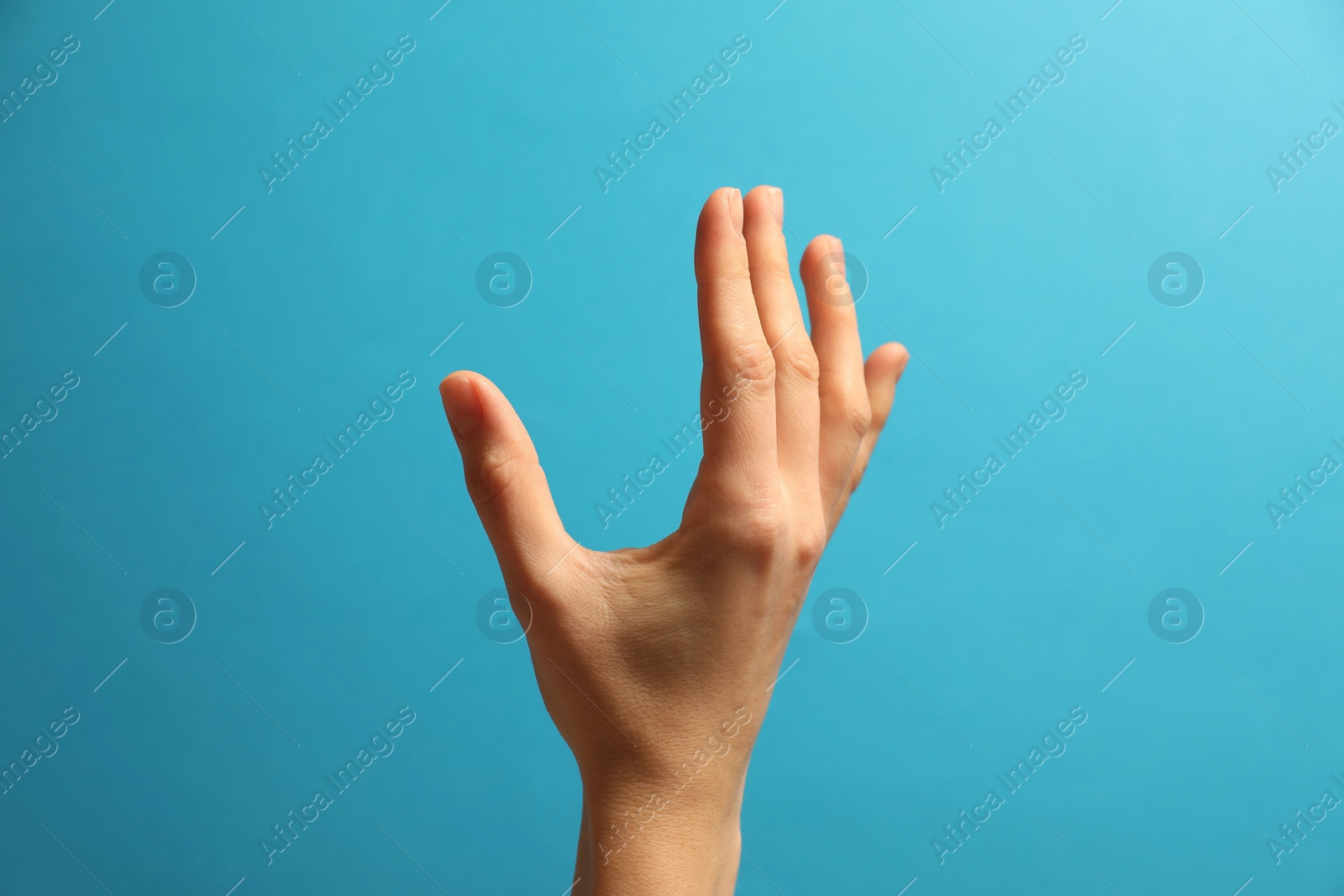 Photo of Woman holding something in hand on light blue background, closeup