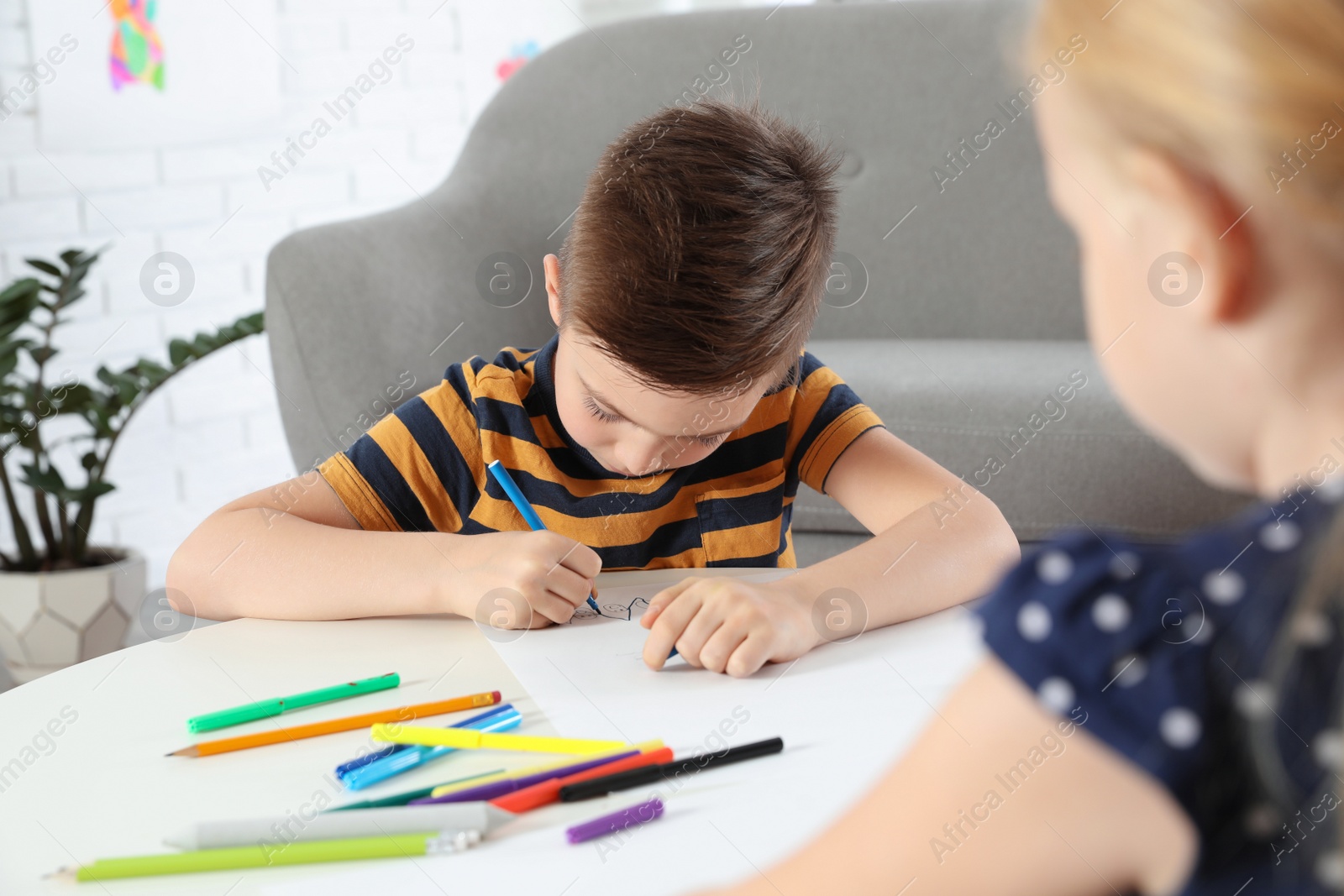 Photo of Cute little children drawing together at home