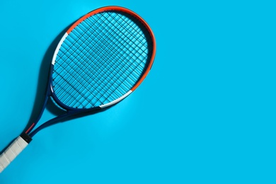 Photo of Tennis racket on blue background, top view. Space for text