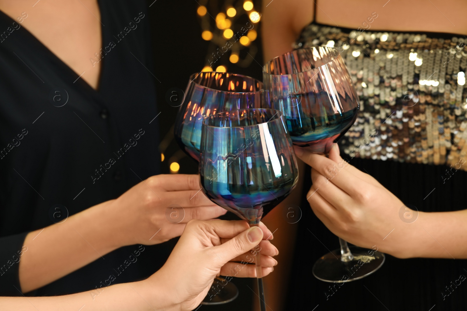 Photo of Women clinking glasses of red wine at party, closeup