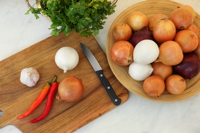 Photo of Fresh onions, chili peppers and garlic on table, flat lay