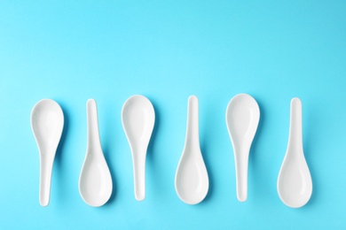 Miso soup spoons on blue background, flat lay