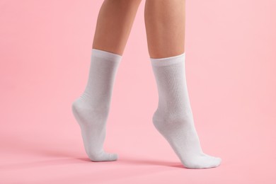 Photo of Woman in stylish white socks on pink background, closeup