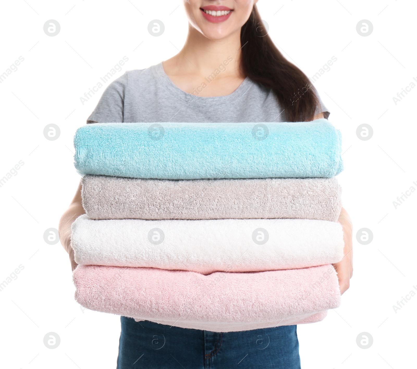 Photo of Young woman holding clean towels on white background, closeup. Laundry day