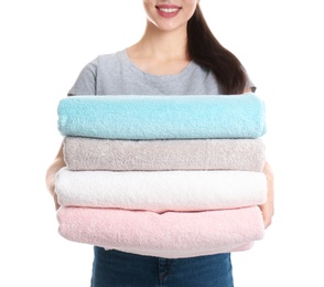 Young woman holding clean towels on white background, closeup. Laundry day